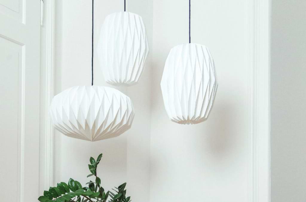 Drei weiße gefaltete Nachtfalter Pendelleuchten in hellem minimalistischen Interior mit nachhaltigem Design aus Hamburg