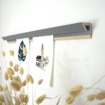 Holzregal mit Bild und Dekoration auf grauer Wand