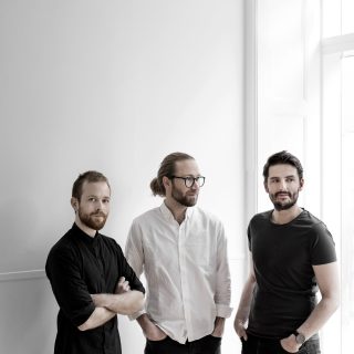Drei Männer im weißen Raum des Hamburger Designladens posing für eine Fotografie von Chris Tonnesen