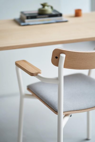 Weißer Designmoebel-Stuhl mit schwarzem Sitz von tiptoe, auf weißem Tisch, Laptop daneben – nachhaltiges Design-Interior